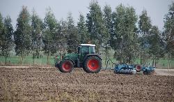 Agricoltore al lavoro con mezzi agricoli